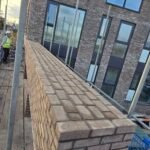 Brickwork installation along balcony edge on residential building