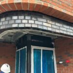 Brick arch construction with detailed masonry brickwork around residential doorway