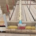 Cavity insulation installed at floor junction with moisture protection