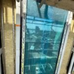 Cavity wall insulation installation progressing along scaffolded elevation